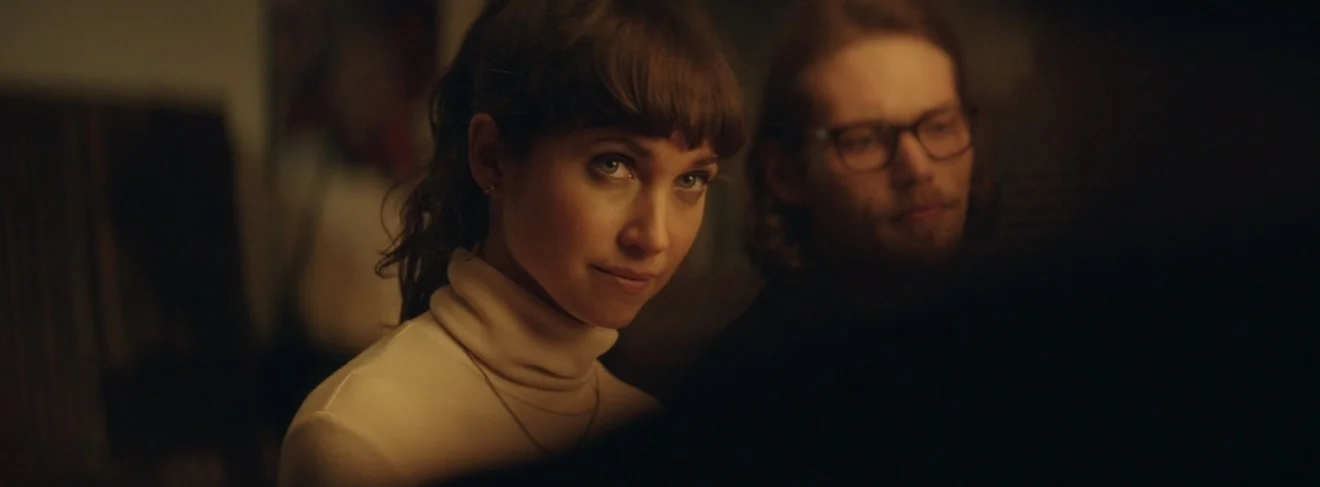 Two characters in a warm-lit scene from Bight
