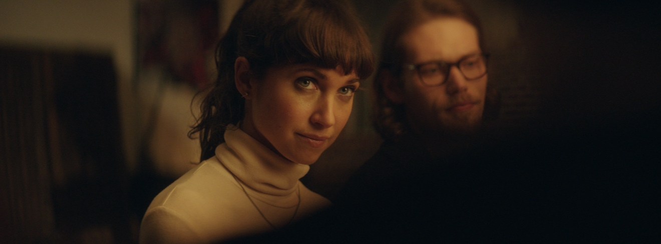 Two characters in a warm-lit scene from Bight